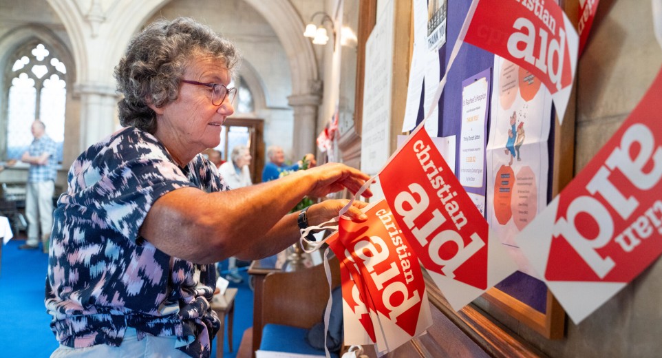 Supporter handing Christian Aid bunting in their church