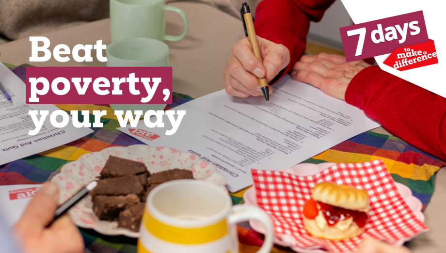 A table displaying baked goods like brownies, jam and cream scones and cups of tea. A person is leant on the table, wearing a red shirt and filling in a Christian Aid quiz.
