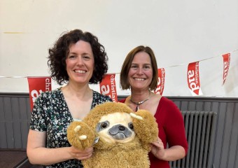 Christian Aid volunteers Vikki and Saran holding a toy "Sid the Sloth" at a quiz night fundraiser 