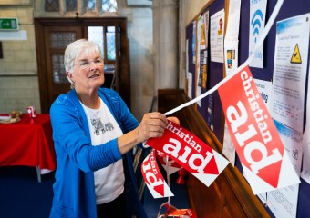 supporter putting up Christian Aid banners
